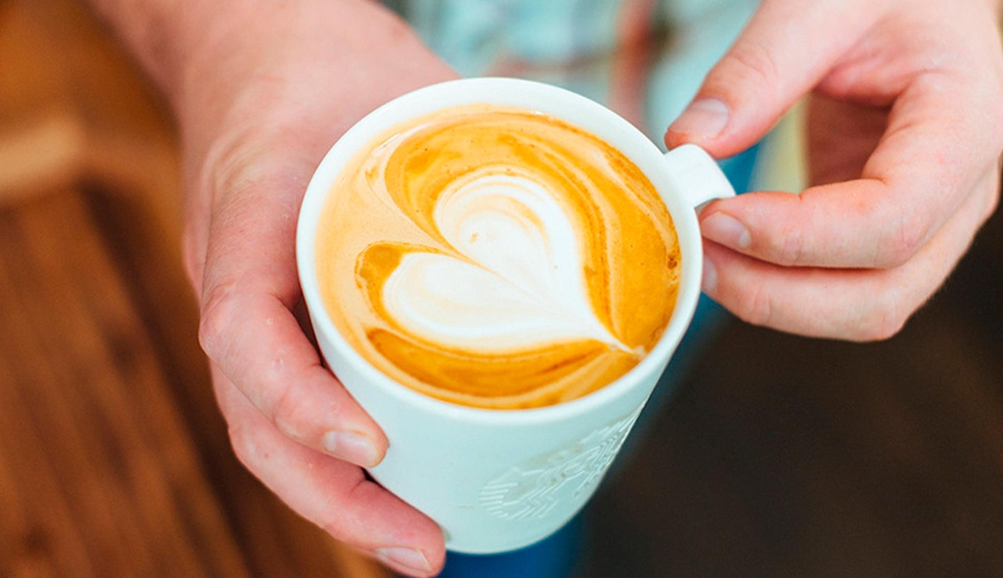 Hands pouring heart latte art